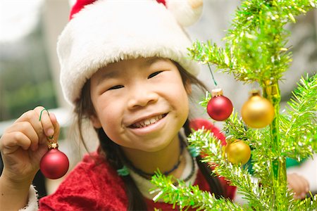 single christmas ball ornament - Closeup of girl decorating Christmas tree Stock Photo - Premium Royalty-Free, Code: 673-02140589