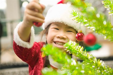 single christmas ball ornament - Happy girl decorating Christmas tree Stock Photo - Premium Royalty-Free, Code: 673-02140591