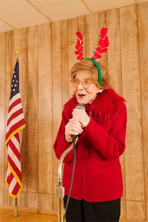 Elderly woman at microphone at Christmastime Stock Photo - Premium Royalty-Free, Code: 673-02140609