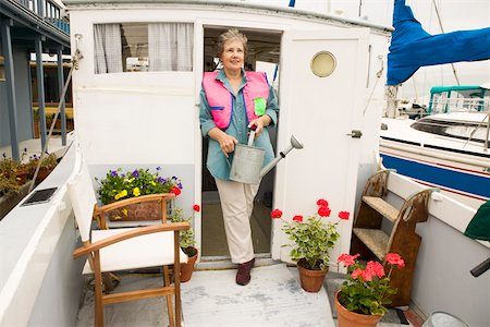 Woman on houseboat watering plants Foto de stock - Sin royalties Premium, Código: 673-02140620