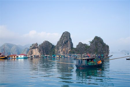 simsearch:673-02140712,k - Floating Vietnamese fishing village with rocky coastline Stock Photo - Premium Royalty-Free, Code: 673-02140684