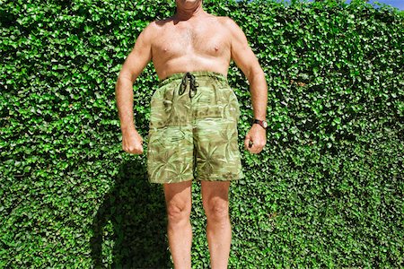 Man posing comically in swimming trunks Stock Photo - Premium Royalty-Free, Code: 673-02140745