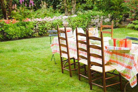 Table and chairs on lawn in garden Stock Photo - Premium Royalty-Free, Code: 673-02140747