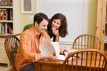 Smiling couple doing paperwork at home Stock Photo - Premium Royalty-Free, Code: 673-02140796
