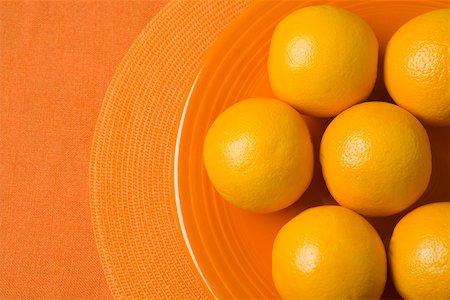 Whole oranges on orange plate Stock Photo - Premium Royalty-Free, Code: 673-02140859