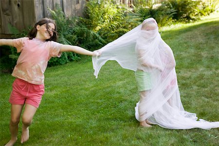 Young girl wrapping friends in fabric Stock Photo - Premium Royalty-Free, Code: 673-02140895