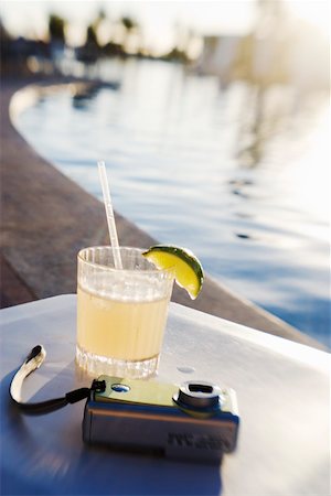 Margarita and camera on poolside table Stock Photo - Premium Royalty-Free, Code: 673-02140915