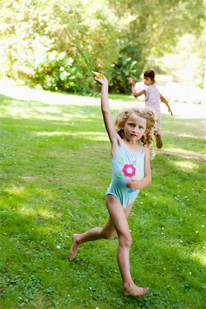 Girl in bathing suit flying kite Foto de stock - Sin royalties Premium, Código: 673-02140941