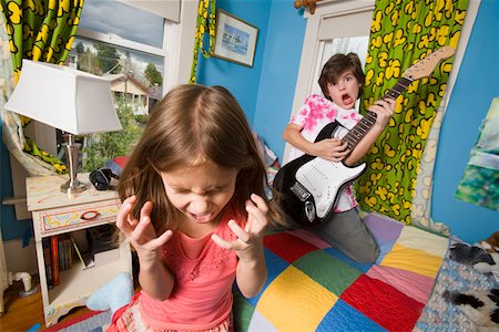 Girl screaming while boy plays guitar Stock Photo - Premium Royalty-Free, Code: 673-02141198