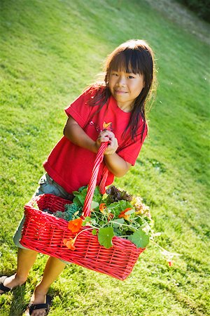 Young girl carrying basket of plants outdoors Stock Photo - Premium Royalty-Free, Code: 673-02141436