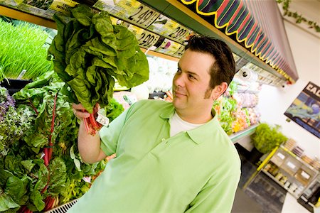 Man wary of green plant in supermarket Stock Photo - Premium Royalty-Free, Code: 673-02141455