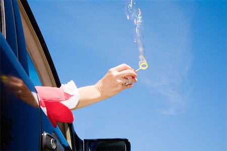 simsearch:673-02143413,k - Woman blowing bubbles out car window Stock Photo - Premium Royalty-Free, Code: 673-02141451