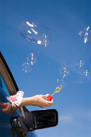 simsearch:673-02143413,k - Woman blowing bubbles out car window Stock Photo - Premium Royalty-Free, Code: 673-02141452