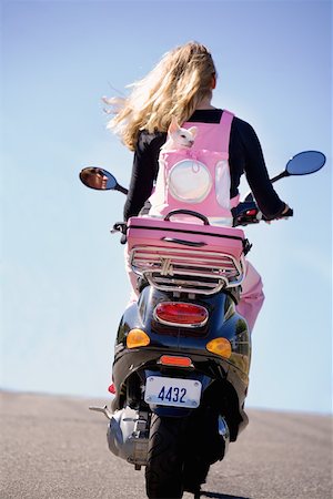 Woman carrying her small dog on a scooter Stock Photo - Premium Royalty-Free, Code: 673-02141478