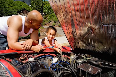 dad with tattoos - Young boy helping his father work on car Stock Photo - Premium Royalty-Free, Code: 673-02141577