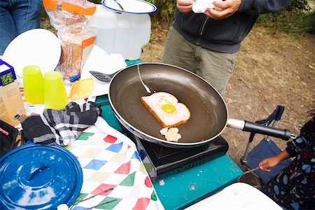 person frying eggs - People cooking breakfast at campsite Stock Photo - Premium Royalty-Free, Code: 673-02141618