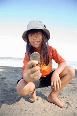 simsearch:673-02143353,k - Jeune fille affichant un dollar de sable sur la plage Photographie de stock - Premium Libres de Droits, Code: 673-02141631