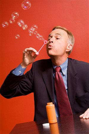 exhale mature - Businessman blowing bubbles Stock Photo - Premium Royalty-Free, Code: 673-02141775