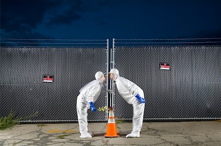 paranoia - People in biohazard suits kissing over orange safety cone Stock Photo - Premium Royalty-Free, Code: 673-02141805