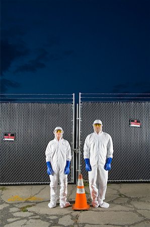 People in biohazard suits standing around orange safety cone Stock Photo - Premium Royalty-Free, Code: 673-02141806