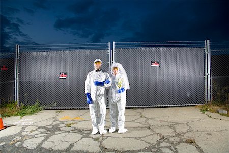 précaution - People in biohazard suits standing outside security gate Foto de stock - Sin royalties Premium, Código: 673-02141801