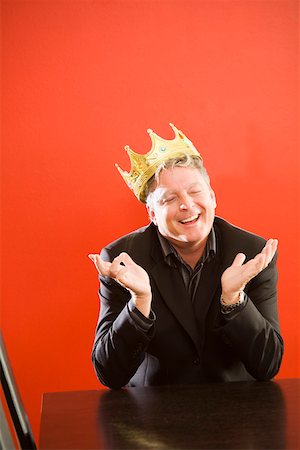 Businessman wearing gold crown in conference room Stock Photo - Premium Royalty-Free, Code: 673-02142073