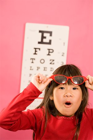 Fille portant des lunettes de vue en face de la Charte de le œil Photographie de stock - Premium Libres de Droits, Code: 673-02142111