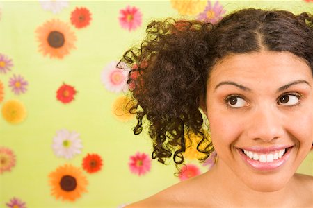 Woman looking sideways in front of flower background Stock Photo - Premium Royalty-Free, Code: 673-02142179