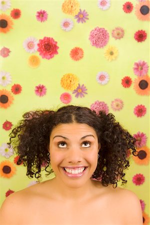 simsearch:673-02142185,k - Woman looking up in front of flower background Fotografie stock - Premium Royalty-Free, Codice: 673-02142186