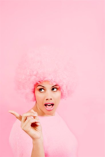 Woman wearing pink wig and pointing Stock Photo - Premium Royalty-Free, Image code: 673-02142193