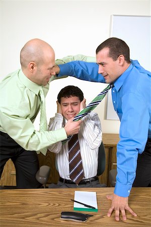 fighting to protect - Two businessmen fighting above co worker Stock Photo - Premium Royalty-Free, Code: 673-02142254