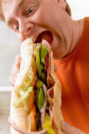 simsearch:673-02142407,k - Man eating a sandwich Stock Photo - Premium Royalty-Free, Code: 673-02142331