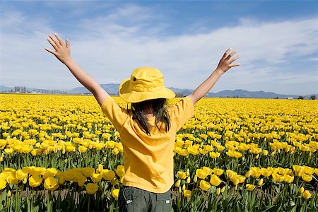 simsearch:673-02143353,k - Jeune fille debout dans le champ de fleurs jaunes Photographie de stock - Premium Libres de Droits, Code: 673-02142349