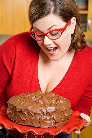 Woman inspecting frosted cake Stock Photo - Premium Royalty-Free, Code: 673-02142393