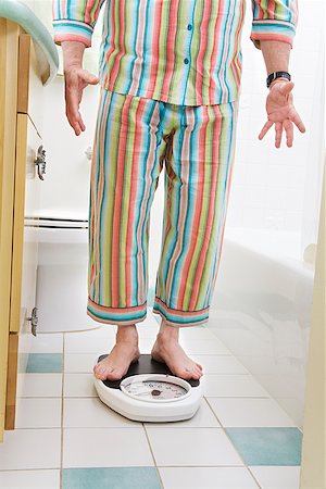 fat matures 40 year old man - Man weighing himself in bathroom Stock Photo - Premium Royalty-Free, Code: 673-02142447