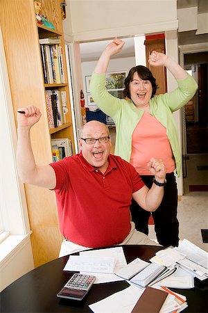 person writing in check book - Couple celebrating after paying bills Stock Photo - Premium Royalty-Free, Code: 673-02142506