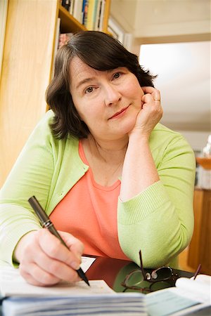 Woman writing a check Stock Photo - Premium Royalty-Free, Code: 673-02142513