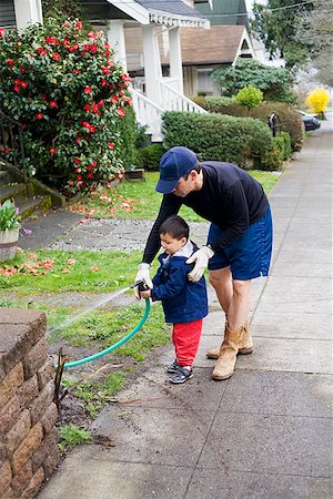 father advising son - Father and son watering plants Stock Photo - Premium Royalty-Free, Code: 673-02142660