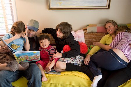 sister hugs baby - Family reading on sofa Stock Photo - Premium Royalty-Free, Code: 673-02142682