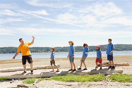 Male camp counselor with children at beach Stock Photo - Premium Royalty-Free, Code: 673-02142823