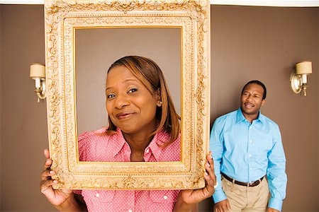 simsearch:673-02143137,k - African woman looking through picture frame Fotografie stock - Premium Royalty-Free, Codice: 673-02142833
