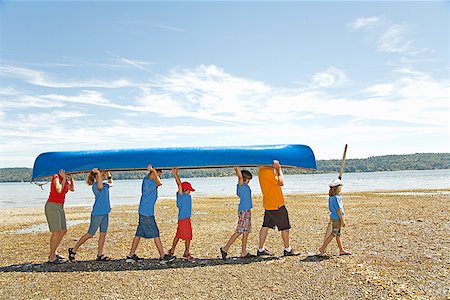 reaching sky - Male camp counselor and children carrying canoe Stock Photo - Premium Royalty-Free, Code: 673-02142940
