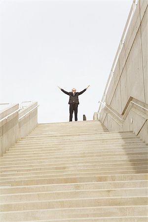 staircase of challenges - Businessman with arms raised at top of steps Stock Photo - Premium Royalty-Free, Code: 673-02142985