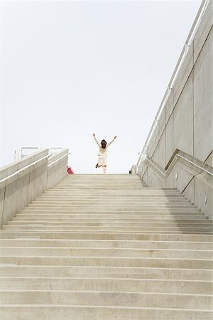 Businesswoman with arms raised at top of steps Stock Photo - Premium Royalty-Free, Code: 673-02142988