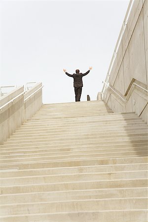 daunting - Businessman with arms raised at top of steps Stock Photo - Premium Royalty-Free, Code: 673-02142983