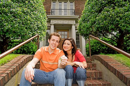 Hispanic couple sitting in front of new house Stock Photo - Premium Royalty-Free, Code: 673-02143030