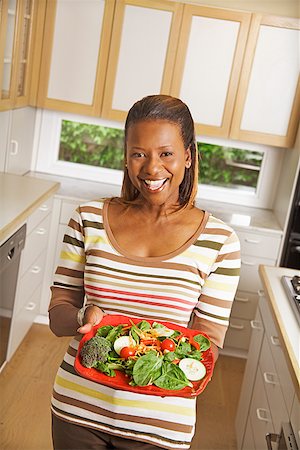 simsearch:673-02143115,k - African woman holding plate of vegetables Stock Photo - Premium Royalty-Free, Code: 673-02143104