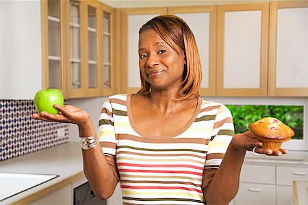 simsearch:673-02143115,k - African woman holding apple and muffin Stock Photo - Premium Royalty-Free, Code: 673-02143111