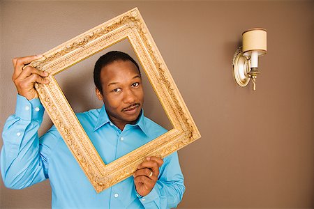 simsearch:673-02143816,k - African man looking through picture frame Stock Photo - Premium Royalty-Free, Code: 673-02143135