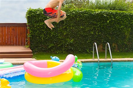 profile of boy jumping - Boy jumping into swimming pool Stock Photo - Premium Royalty-Free, Code: 673-02143231